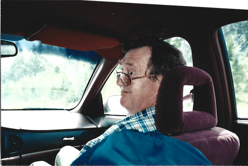 A picture of my dad looking back from the front seat of a car and making a funny face